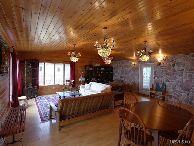 dining room with an inviting chandelier, lofted ceiling, wood finished floors, and a wealth of natural light