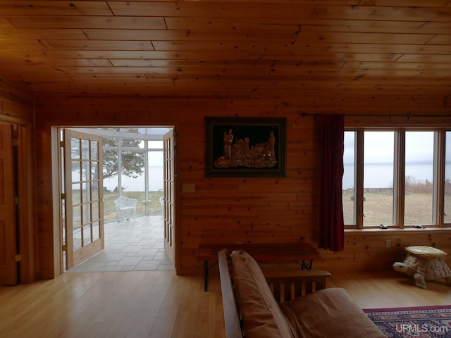living room with light wood-type flooring, wood walls, and wooden ceiling