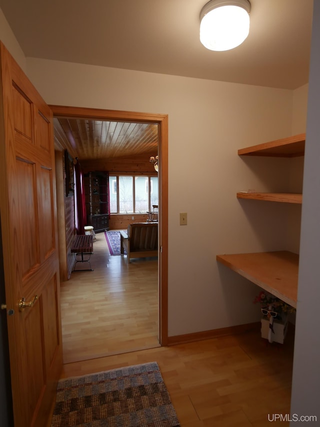 hall with wood ceiling and light wood-style flooring
