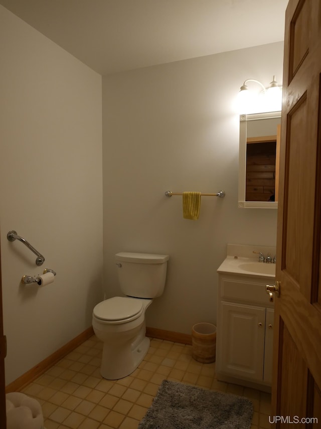 bathroom featuring vanity, tile patterned flooring, baseboards, and toilet