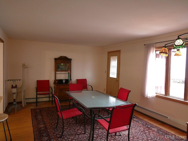dining area featuring baseboard heating and wood finished floors