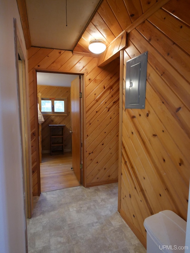 corridor with electric panel and wood walls