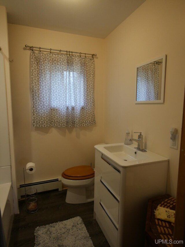 full bath featuring baseboard heating, wood finished floors, vanity, a shower, and toilet