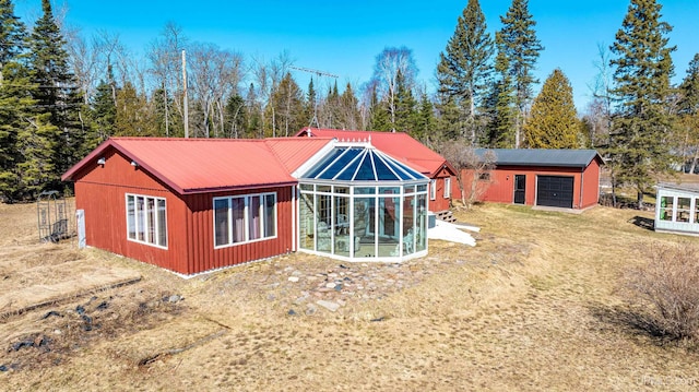 back of house with a sunroom and metal roof