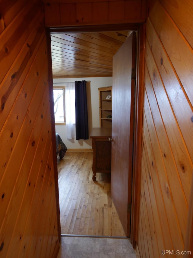 hallway featuring wood walls