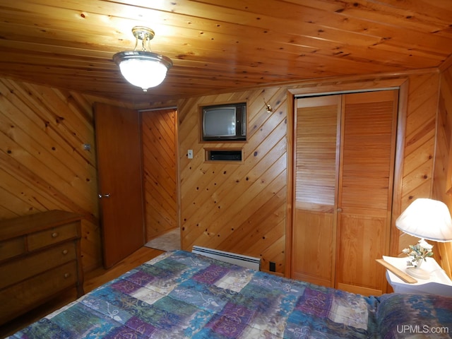 bedroom featuring a baseboard heating unit, wooden walls, a closet, and wood ceiling