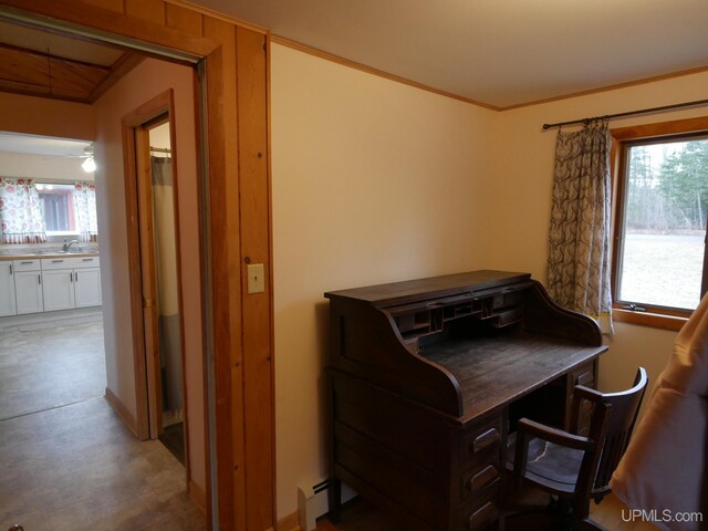 home office featuring light floors, a sink, and a baseboard radiator