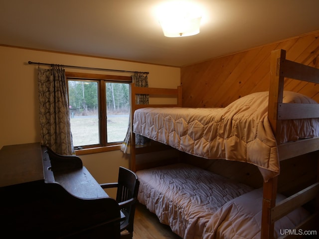 bedroom featuring wooden walls and wood finished floors