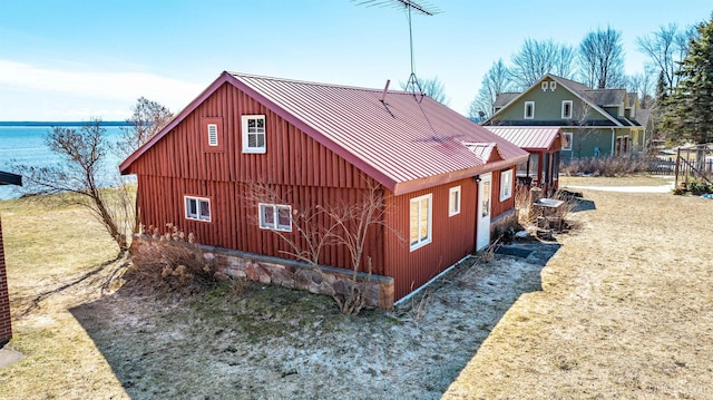 view of side of property with board and batten siding, a standing seam roof, and metal roof