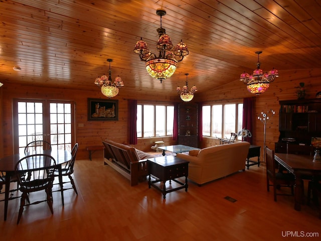 living room with wood finished floors, a healthy amount of sunlight, wooden ceiling, and a notable chandelier