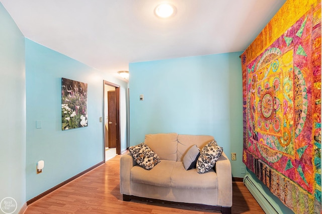 sitting room featuring a baseboard radiator, wood finished floors, and baseboards