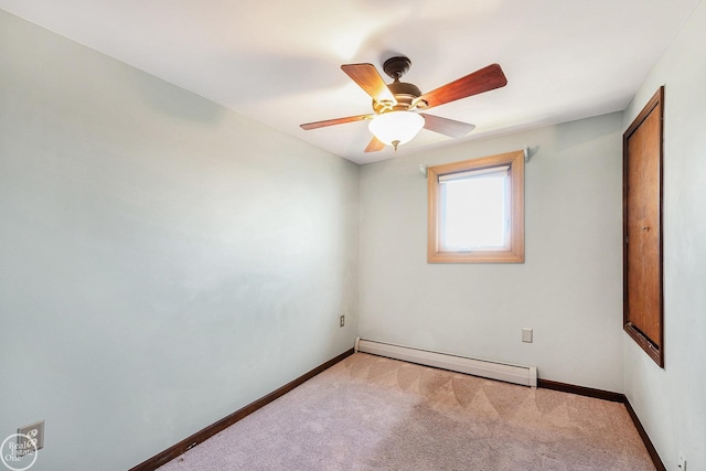 spare room featuring a baseboard heating unit, baseboards, a ceiling fan, and carpet floors