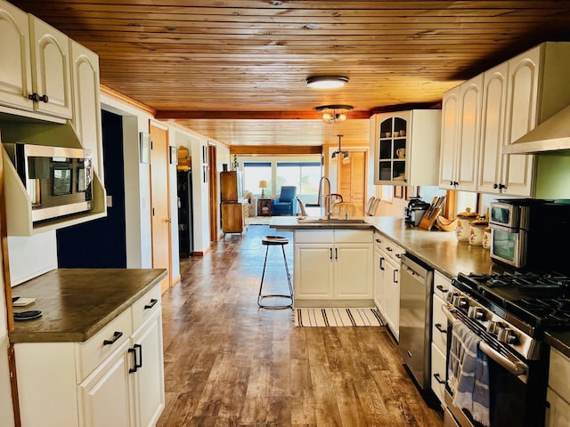 kitchen with dark wood-style floors, dark countertops, wood ceiling, a peninsula, and appliances with stainless steel finishes