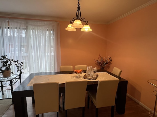 dining area featuring baseboards, crown molding, and wood finished floors