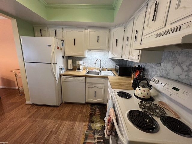 kitchen featuring dark wood-type flooring, crown molding, a sink, and white appliances