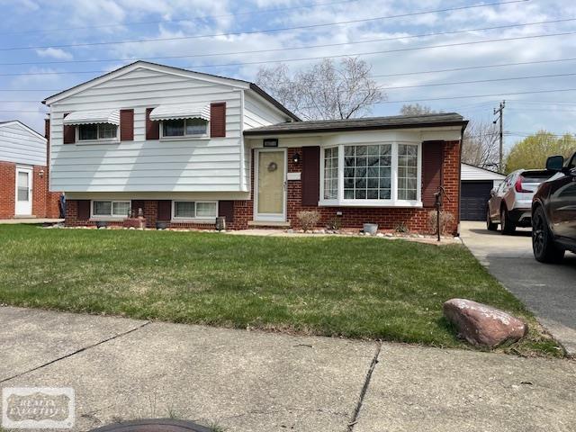 30750 Sutherland Ave, Warren, MI 48088 - tri-level home featuring brick siding, a front yard, and a detached garage