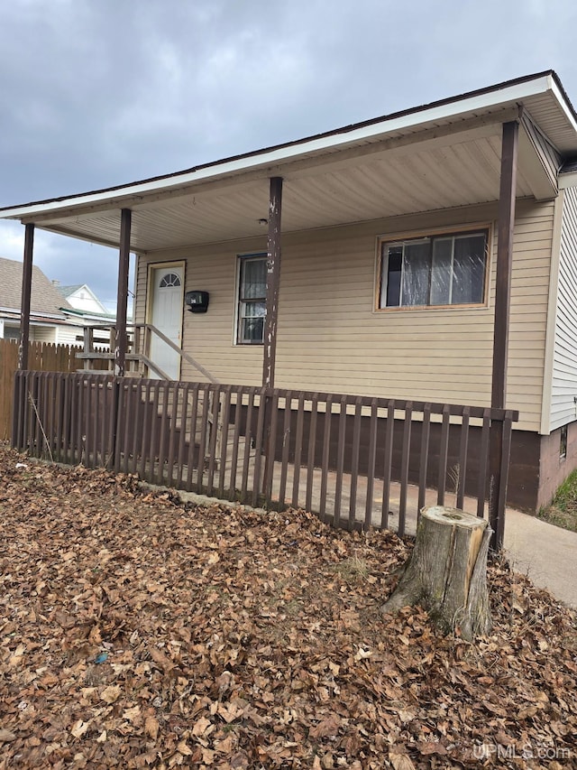 view of front facade featuring a porch and fence