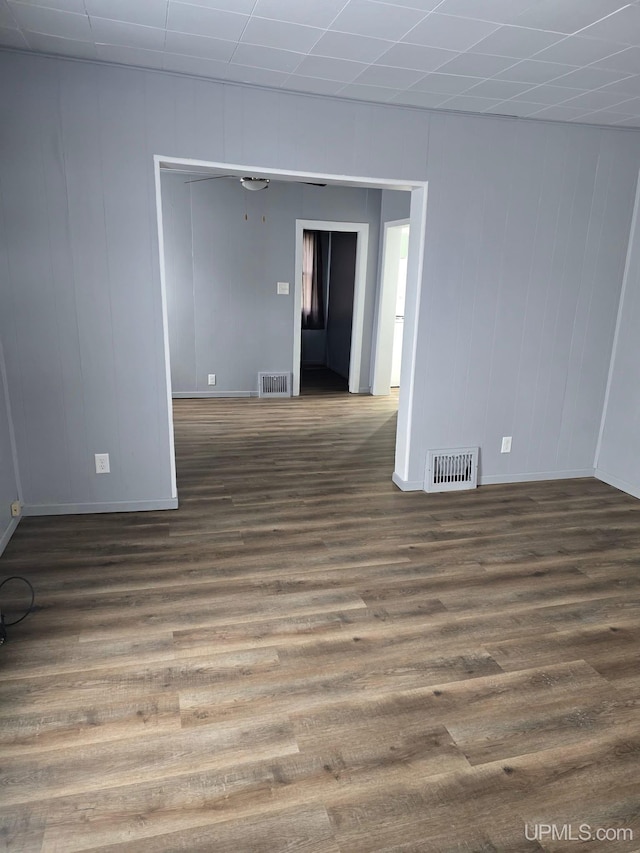 spare room featuring baseboards, wood finished floors, and visible vents