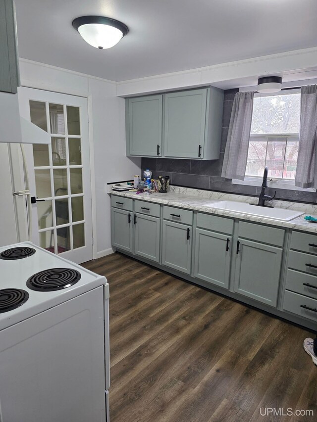 kitchen with gray cabinets, dark wood-style floors, a sink, and white appliances
