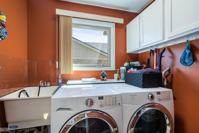 washroom featuring cabinet space and washer and clothes dryer