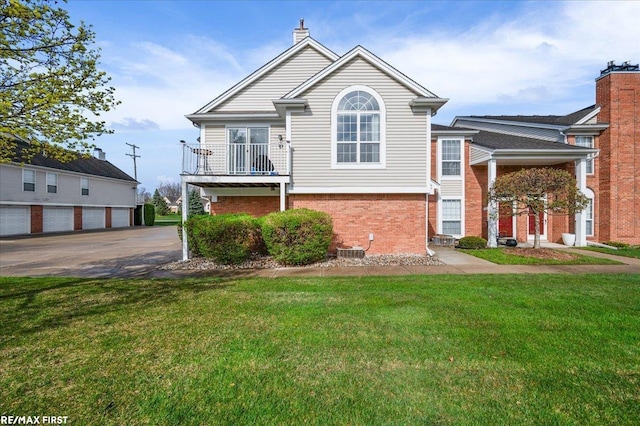tri-level home featuring brick siding and a front lawn