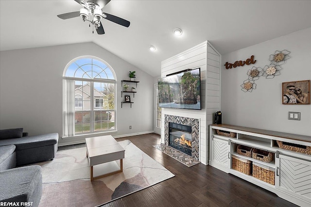 living room with ceiling fan, a tiled fireplace, lofted ceiling, dark wood-style floors, and recessed lighting