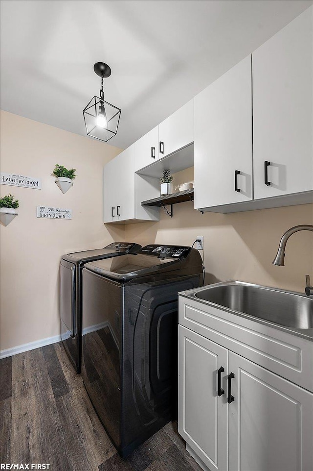laundry room with a sink, dark wood-type flooring, independent washer and dryer, baseboards, and cabinet space