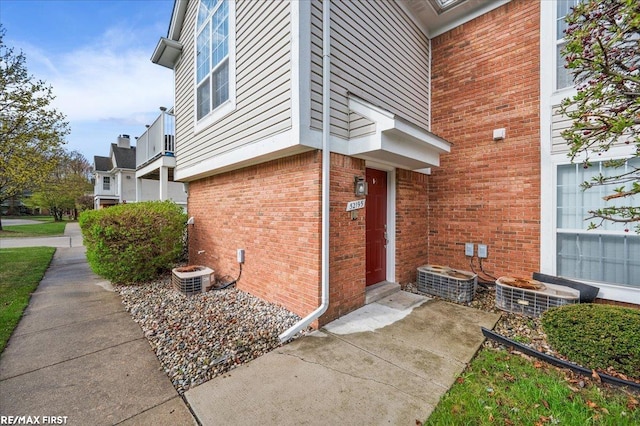 view of property exterior featuring brick siding and central air condition unit