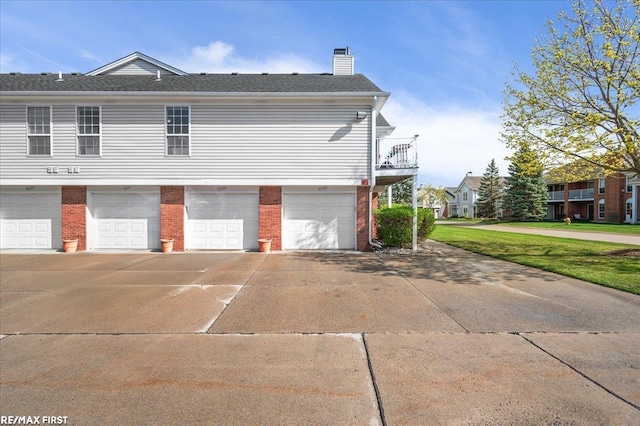 view of property exterior featuring concrete driveway, a chimney, brick siding, and a garage