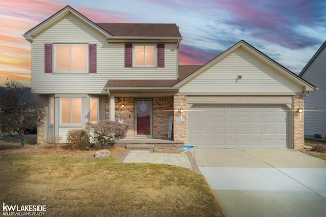 traditional home with concrete driveway, a garage, brick siding, a lawn, and a shingled roof