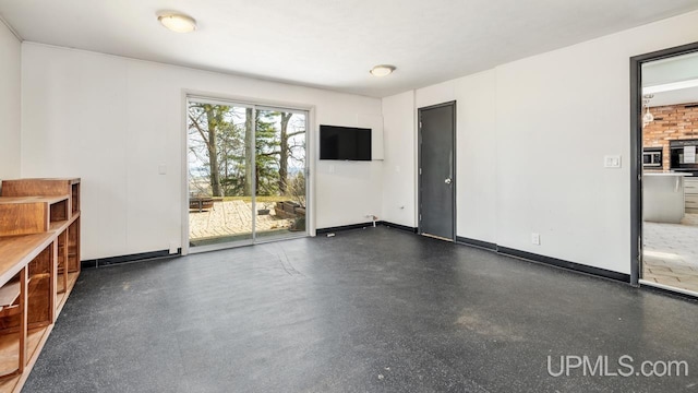 unfurnished living room featuring baseboards