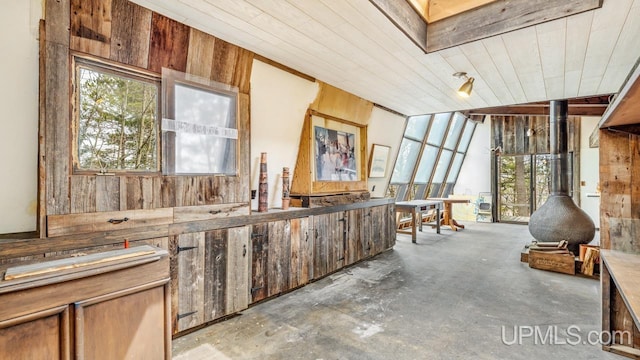 interior space featuring wood ceiling, wood walls, and concrete floors