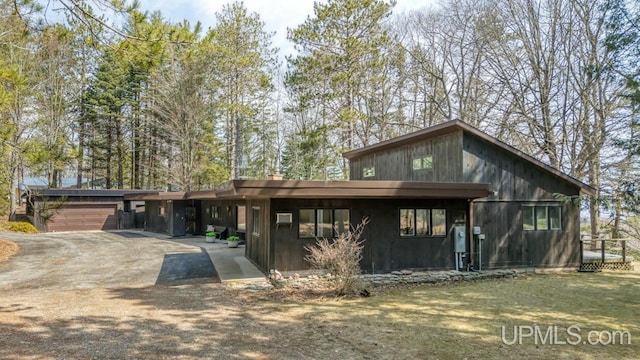 mid-century home featuring driveway and a garage