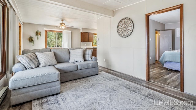 living area with a baseboard radiator, wood finished floors, and ceiling fan