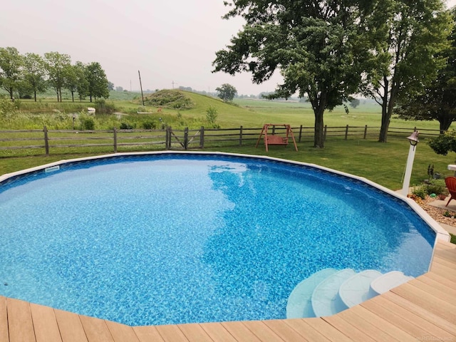 pool with a rural view, a yard, and a fenced backyard