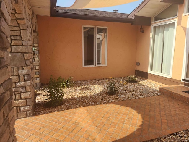 view of side of home with a patio area and stucco siding