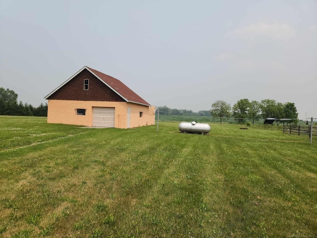 view of yard featuring fence, a rural view, and an outdoor structure