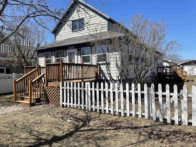 view of front of property featuring a deck and a fenced front yard