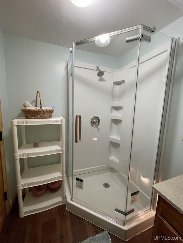 full bathroom featuring vanity, wood finished floors, and a stall shower