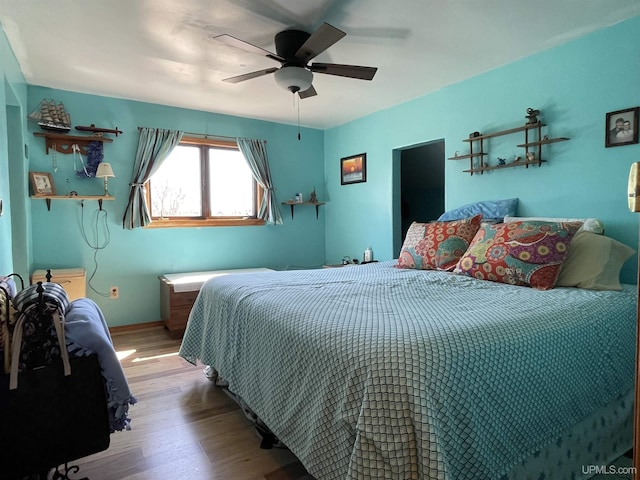 bedroom featuring wood finished floors and a ceiling fan