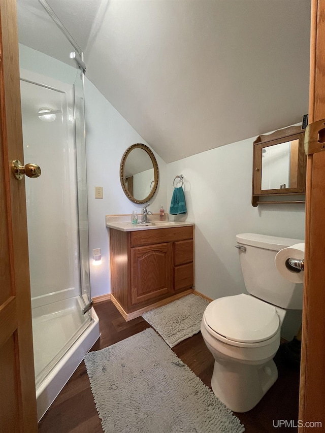 full bathroom with a shower stall, vaulted ceiling, toilet, wood finished floors, and baseboards