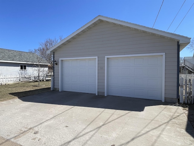 detached garage featuring fence