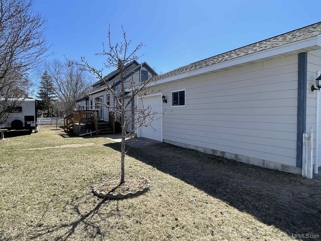 back of property featuring a lawn and a garage