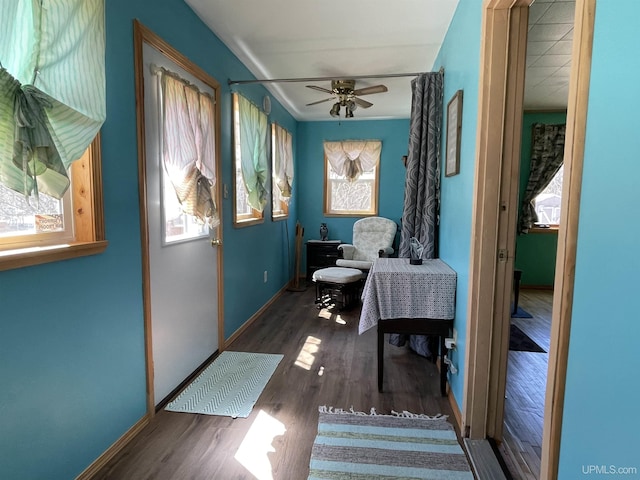 sitting room with ceiling fan, baseboards, and wood finished floors