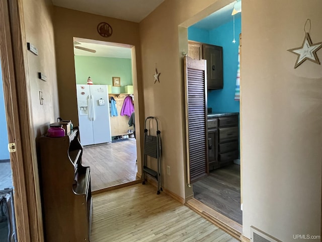 corridor featuring baseboards and light wood-style floors