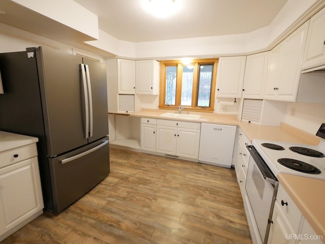 kitchen with white cabinets, white appliances, a sink, and light wood-style floors