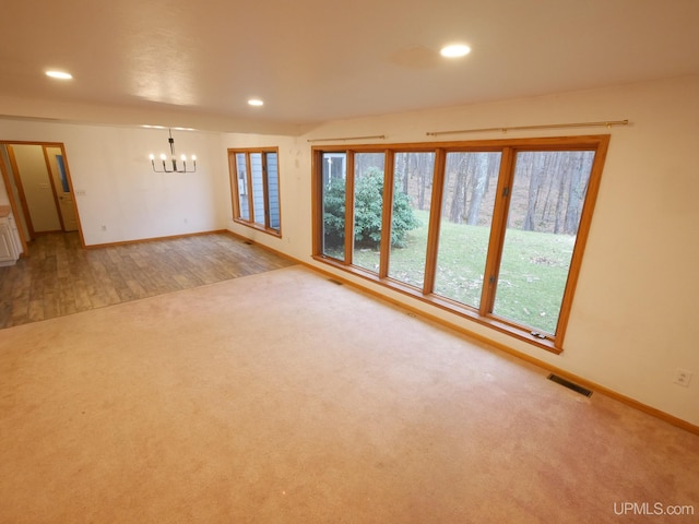 unfurnished room with a chandelier, light carpet, baseboards, visible vents, and recessed lighting