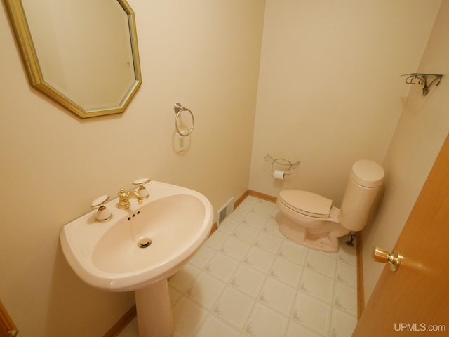 bathroom featuring tile patterned floors, baseboards, visible vents, and toilet