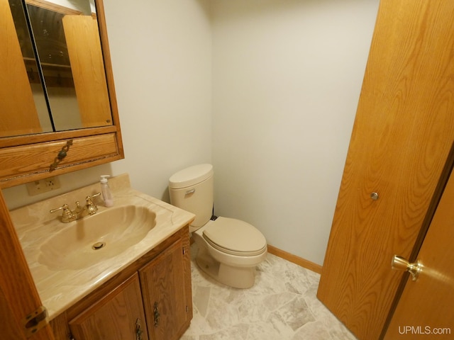 bathroom featuring baseboards, toilet, and vanity