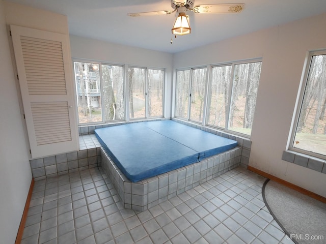 interior space with baseboards, tile patterned floors, and a wealth of natural light